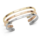 Three slim cuff bracelets in rose gold, silver, and gold tones with sparkling crystal accents and engraved detail, displayed together to highlight their elegant, minimalist design and versatility for layering.