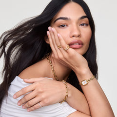 A woman wearing the Quadro Mini Arch 3-link White Sunray Rose Gold watch styled with gold jewellery, highlighting the petite rectangular case and polished rose gold bracelet for a refined, everyday look.