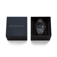 Daniel Wellington Iconic Link Automatic Black watch with a black stainless steel bracelet, presented in its branded gift box with the lid beside it.