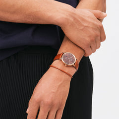Classic Multi-Eye St Mawes Amber Rose Gold men's watch worn on the wrist, featuring a rose gold case, amber brown dial, and a genuine brown leather strap, styled with casual clothing for a versatile everyday look.