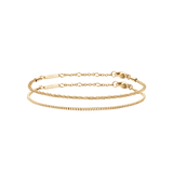 Two gold chain bracelets from the Staple Bracelet Set G, featuring delicate links and adjustable clasps, styled for versatile layering or solo wear.